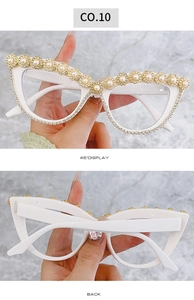 Dettaglio occhiali da sole cat eye con perle bianche e decorazione catena floreale di diamanti