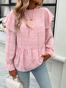 Detail of floral pink blouse showing ruffle stand collar and white polka dot pattern