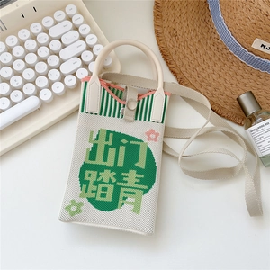 Close-up of cream knitted crossbody bag with green stripes and woven Chinese characters