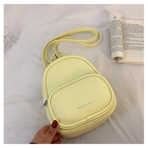 Detail of light yellow PU leather mini backpack with Fashion Bags text and slim straps