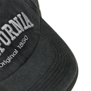 Detailed close-up of California 3D embroidery on washed charcoal cotton baseball cap