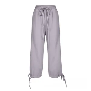 Detail of grey-purple linen trousers with drawstring waist and adjustable hem ties