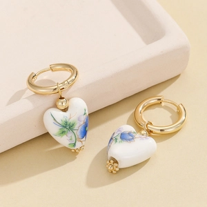 Ceramic heart earrings with blue floral patterns and gold stainless steel hoops