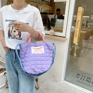 Détail du sac matelassé lilas à motifs cœurs avec bandoulière bleue et étiquette