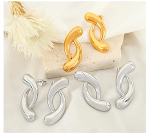 Detailed view of twisted geometric hoop earrings in polished gold and silver finishes