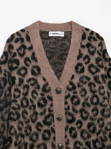 Close-up of the fuzzy leopard print knit texture and dark brown buttons on V-neck cardigan