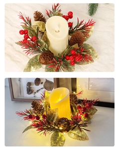 Détail d'une bougie LED avec pommes de pin et baies rouges sous une lumière chaude