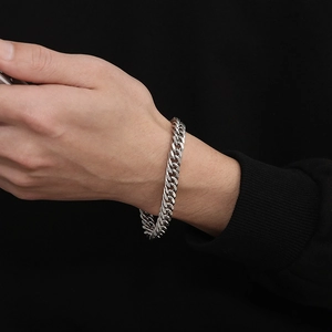 Detailed view of silver stainless steel Cuban link bracelet with OT clasp on wrist