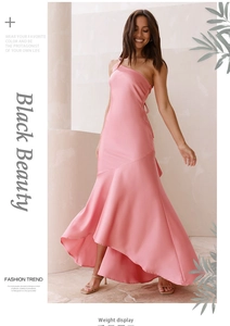 Detail of pink one-shoulder satin dress featuring a flowing fishtail hem and glossy fabric