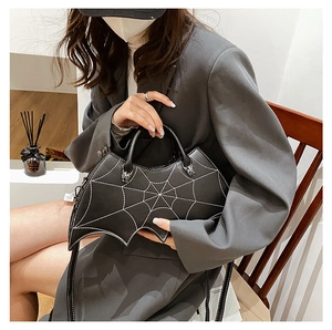 Detail of gothic bat-shaped PU leather handbag featuring white cobweb stitching decoration