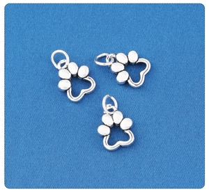 Macro view of three silver hollow paw print charms for DIY jewelry making and crafts