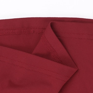 Détail du tissu en maille rouge foncé montrant les coutures doubles et la texture