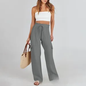Detailed close-up of grey linen cargo pants with drawstring waist and flap pockets