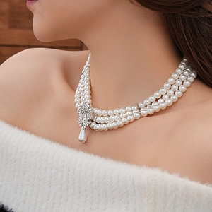 Detail of multi-layer pearl necklace with rhinestone clover clasp and teardrop pendant