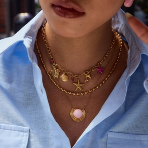 Gold layered necklace featuring ocean charms like turtles and pink natural stone pendants