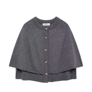 Close-up of gray knit poncho sweater showing round neck and single-breasted button detail