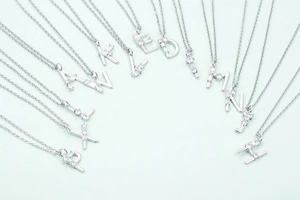 Macro shot of silver 18K gold-plated letter pendants with sparkling micro-pave zircons