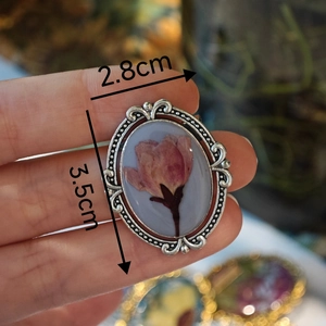 Detail of vintage handmade silver brooch with pink dried flower, 2.8cm by 3.5cm size