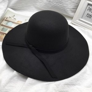 Classic black wide-brim wool cloche hat with ribbon bow detail on white fabric background