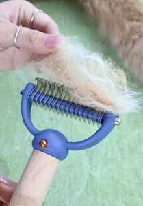 Close-up of beechwood pet grooming brush removing loose fur with stainless steel blades