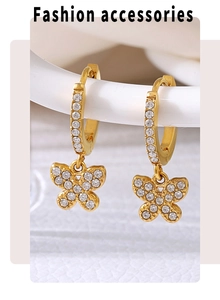 Detailed close-up of gold butterfly hoop earrings with sparkling zircon inlay