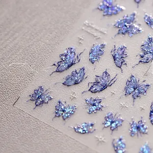 Detail macro view of 3D embossed blue butterfly nail stickers with holographic laser glitter