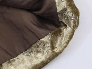 Macro shot of brown lining with gold velvet trim and silver sequins on the suit fabric