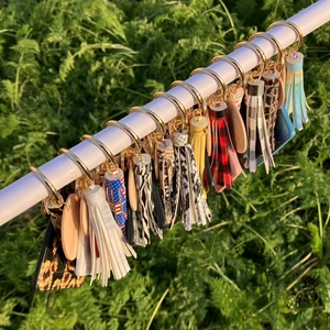 Close-up of tassel keychains with leopard print and zebra patterns on a display bar