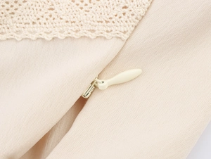 Detailed close-up of beige lace texture and invisible zipper on the camisole top