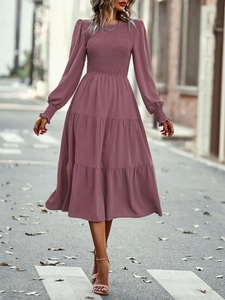 Détail d'une robe mi-longue vieux rose à manches longues avec taille plissée et jupe à étages