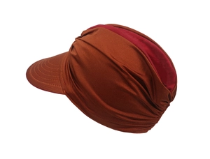 Detail of pleated bronze fabric sun hat with contrasting red lining and fine stitching
