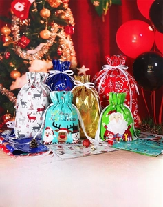 Detail of Christmas drawstring gift bags featuring reindeer and Santa Claus designs