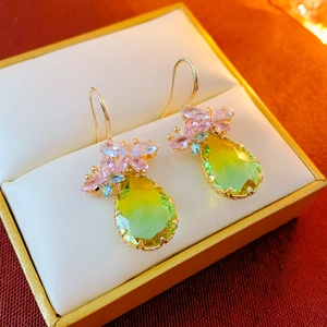 Detailed close-up of zircon butterfly drop earrings with green and pink stones