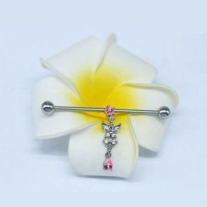 Macro shot of silver industrial barbell with pink zirconia butterfly on plumeria