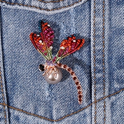 Spilla libellula in strass colorati con perla, elegante accessorio per giacca di jeans.