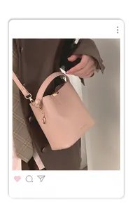 Detailed view of pink leather bucket bag with handle and Macghee embossed logo