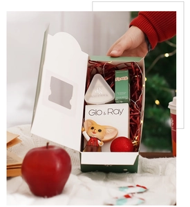 Christmas gift box detail featuring luxury skincare and festive holiday decorations