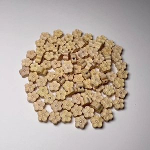 Vue détaillée de perles fleurs de prunier en buis sculptées avec grain de bois naturel