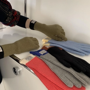 Detail of color-block knit gloves featuring touch-screen tips and a woven wrist label
