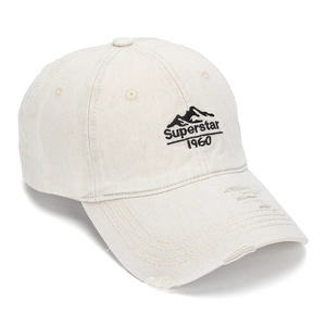 Détail de la visière usée et de la broderie Superstar 1960 sur casquette en coton crème