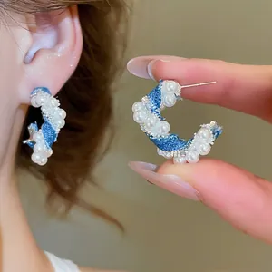 Elegant C-shaped earrings with blue denim fabric, white pearls, and sparkling crystals