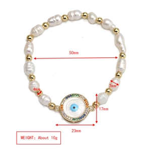 Detailed view of evil eye charm and freshwater pearl bracelet with dimension markings