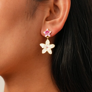 Detail of pink and white enamel flower earrings with sparkling rhinestones on model