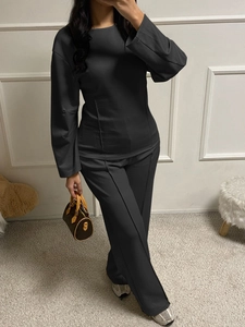 Detail of a dark gray two-piece set featuring long-sleeve top and straight trousers
