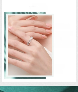 Macro detail of silver ring with marquise-cut zircons in leaf design on finger