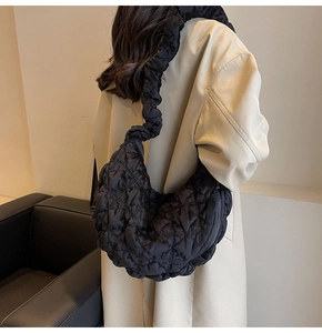 Close-up of black quilted cloud bag with ruched shoulder strap for daily fashion wear