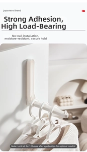 Detail of white folding wall hook showing multi-hole design for multiple hangers