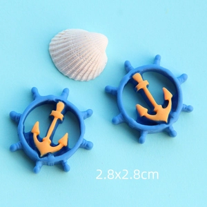 Dettaglio macro di ciondoli a timone in resina blu e arancio per creazioni marine
