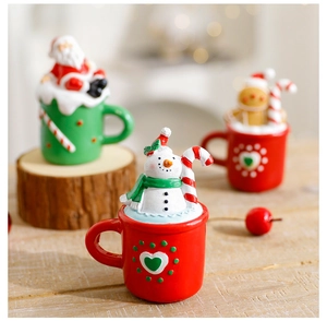 Miniature resin snowman figurine in a festive red Christmas mug with winter decor