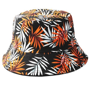 Reversible bucket hat with orange and white palm leaf print on black background